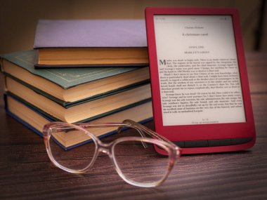 Atmospheric composition on the theme of reading e-books with glasses and old books