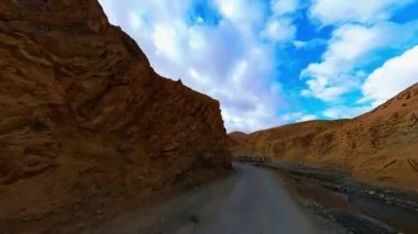 Yol boyunca akan küçük bir nehirle kayalık ve tozlu yollarda ilerlerken dağ otoyolunun engebeli arazisinde araba sürmenin heyecanını yaşayın..