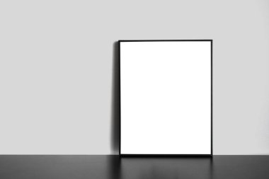 Dikey çerçeve, siyah ahşap masa üzerinde duruyor.