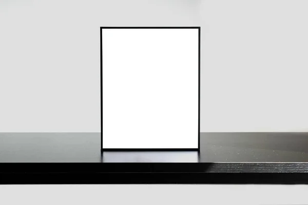 自然な影と黒の木製の机の上に立っ垂直フレーム — ストック写真