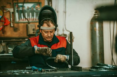 A worker in an industry preparing iron structures for welding. 