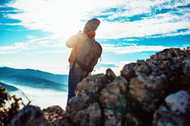 İnsanlar gün doğumunda bir dağa tırmanırken birbirlerine yardım ediyorlar..