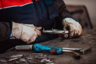 A worker in an industry preparing iron structures for welding. 
