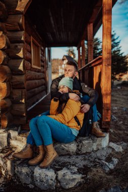 Sevgi dolu bir adam ve kadın kulübelerinin balkonunda oturuyorlar.