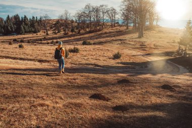 İnsanlar gün doğumunda bir dağa tırmanırken birbirlerine yardım ediyorlar..