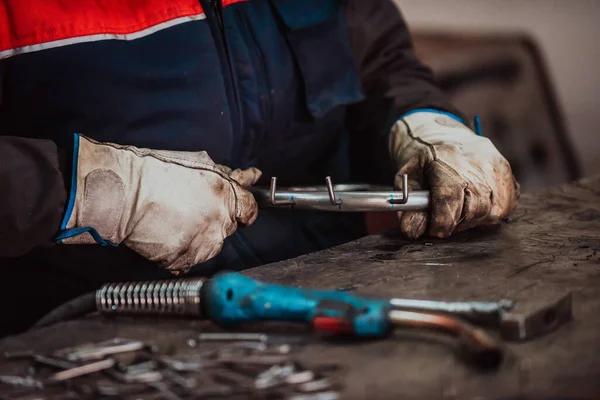 A worker in an industry preparing iron structures for welding. 