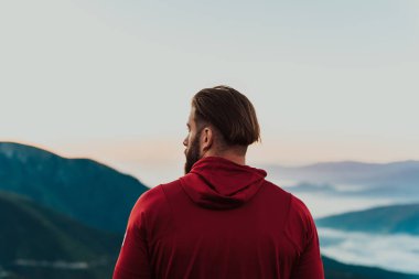 An athlete rests on top of a mountain after exhausting running training