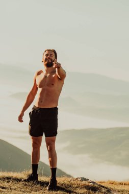 An athlete rests on top of a mountain after exhausting running training