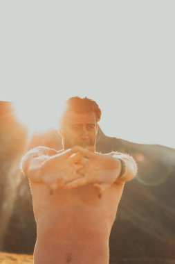A man stretching his arms after a hard workout in the early hours of the morning.
