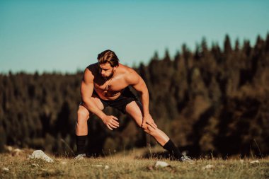 A man stretching after a hard workout in the early hours of the morning. H