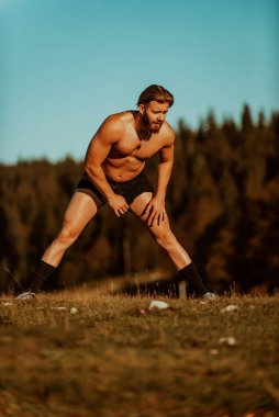 A man stretching after a hard workout in the early hours of the morning. H