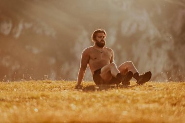 A man doing abs exercises on top of a mountain.