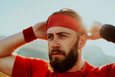 A determined athlete preparing for the start of training on the top of the mountain at sunrise