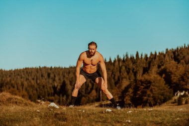 A man stretching after a hard workout in the early hours of the morning. H