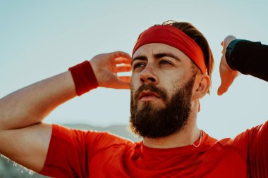A determined athlete preparing for the start of training on the top of the mountain at sunrise