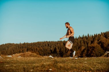 An athlete rests on top of a mountain after exhausting running training