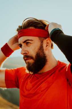 A determined athlete preparing for the start of training on the top of the mountain at sunrise