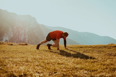 A determined athlete preparing for the start of training on the top of the mountain at sunrise