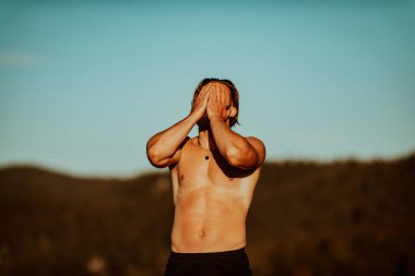 An athlete rests on top of a mountain after exhausting running training