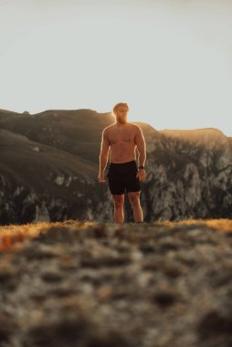 An athlete rests on top of a mountain after exhausting running training