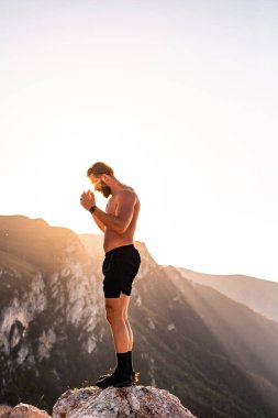 An athlete rests on top of a mountain after exhausting running training