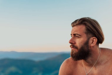 An athlete rests on top of a mountain after exhausting running training