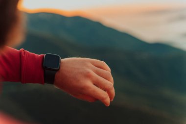 Man Using A Digital Smartwatch During Workout. Closeup View Of Mans Hands Checking An App In Smartwatch. Close-up Of A Clock That Shows Steps, Kilometers And bpm