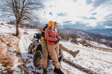 Çiftler kış vakti dağın tepesinde bisiklet sürerken eğleniyorlar.. 