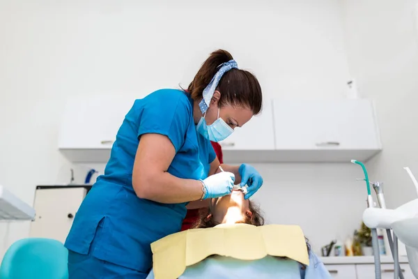 stock image Dentist appointment at a dental clinic, placing braces locks on the teeth and pulling the archwire to fix it. 