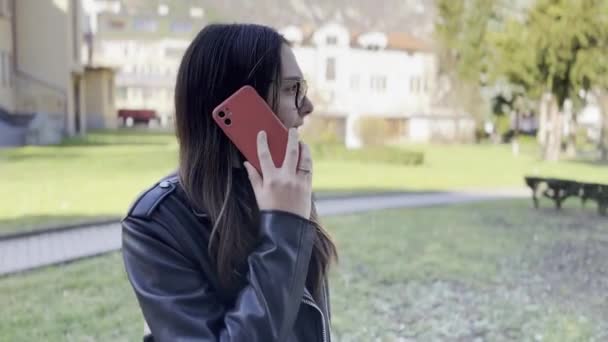 Adolescente Habla Teléfono Inteligente Mientras Está Pie Parque — Vídeo de stock