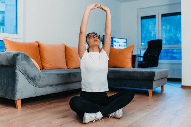 Eğitimden sonra sabah saatlerinde evinde gerinen bir kadın sağlıklı bir yaşam tarzına olan bağlılığını yansıtıyor. Bu an düzenli egzersiz ve kendine bakmanın önemini vurguluyor.