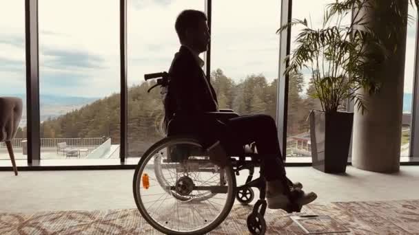 Uśmiechnięty Biznesmen Niepełnosprawnością Bawiący Się Dużym Nowoczesnym Biurze Wózku Inwalidzkim — Wideo stockowe