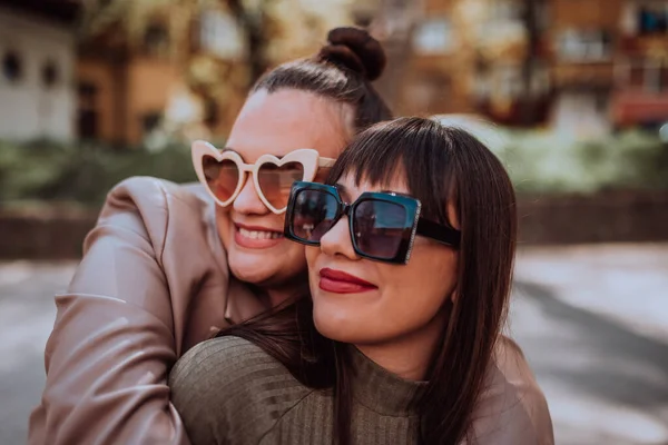Дві Молоді Жінки Обіймаються Емоційно Вулиці Сонячний День Одягаючи Сонцезахисні — стокове фото
