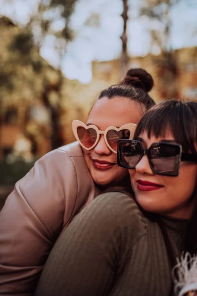 Дві Молоді Жінки Обіймаються Емоційно Вулиці Сонячний День Одягаючи Сонцезахисні — стокове фото