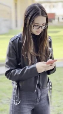 Akıllı telefondan mesaj atan bir kadın. Dikey video. 