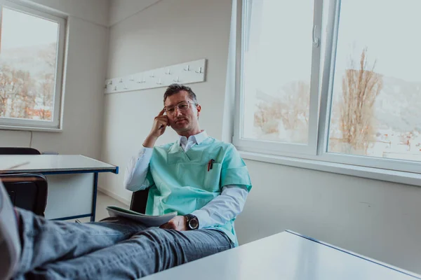 Doctor Sitting Ordination Legs Desk Holding Head Conveys Sense Exhaustion — Stock Photo, Image
