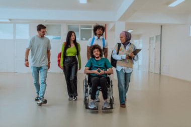 Modern bir üniversitede, aralarında Afro-Amerikalı bir öğrenci ve tesettürlü bir kadının da bulunduğu bir grup öğrenci, tekerlekli sandalyeye mahkum meslektaşlarıyla birlikte koridorda birlikte yürüyorlar.