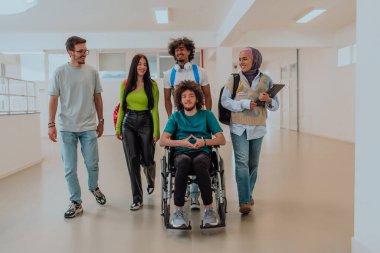 Modern bir üniversitede, aralarında Afro-Amerikalı bir öğrenci ve tesettürlü bir kadının da bulunduğu bir grup öğrenci, tekerlekli sandalyeye mahkum meslektaşlarıyla birlikte koridorda birlikte yürüyorlar.