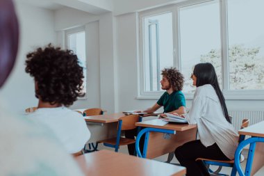 Çeşitli öğrencilerden oluşan bir grup, modern bir sınıfta kendilerini eğiterek, işbirliği ve bilgi alışverişinin gücünü kucaklayarak, canlı bir tartışmaya girişiyor.