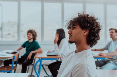 Çeşitli öğrencilerden oluşan bir grup, modern bir sınıfta kendilerini eğiterek, işbirliği ve bilgi alışverişinin gücünü kucaklayarak, canlı bir tartışmaya girişiyor.