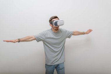 Sanal gerçeklik gözlüğü takan gelecekçi bir adam, izole edilmiş gri bir arka planda havayla etkileşime girer. Yüksek kalite fotoğraf