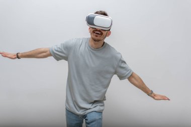 Sanal gerçeklik gözlüğü takan gelecekçi bir adam, izole edilmiş gri bir arka planda havayla etkileşime girer. Yüksek kalite fotoğraf