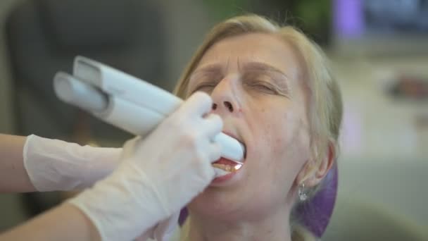 牙医在一家现代诊所检查一位老年妇女的牙齿 为她提供全面的牙科护理 — 图库视频影像