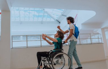 Afrikalı Amerikalı bir öğrenci, arkadaşlarını tekerlekli sandalyeyle modern bir okula sokuyor. Engelli insanlara yardım etme gücünü, ulaşılabilirliğini ve arkadaşlığın gücünü gösteriyor..