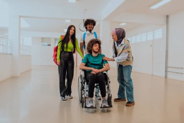 Modern bir üniversitede, aralarında Afrikalı Amerikalı bir öğrenci ve tesettürlü bir kadının da bulunduğu bir grup öğrenci, tekerlekli sandalyeye mahkum meslektaşlarıyla birlikte koridorda yürüyorlar..