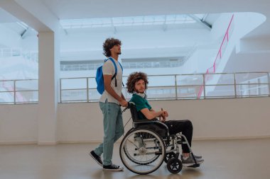 Afrikalı Amerikalı bir öğrenci, arkadaşlarını tekerlekli sandalyeyle modern bir okula sokuyor. Engelli insanlara yardım etme gücünü, ulaşılabilirliğini ve arkadaşlığın gücünü gösteriyor..