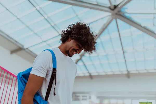 stock image African American student with a blue backpack, sporting a modern Afro hairstyle and a wide smile, radiates enthusiasm and represents the vibrant spirit of a modern university, embodying ambition