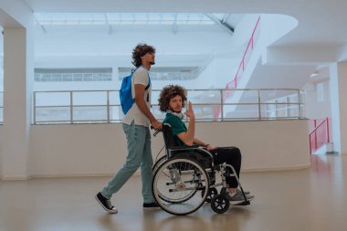 Afrikalı Amerikalı bir öğrenci, arkadaşlarını tekerlekli sandalyeyle modern bir okula sokuyor. Engelli insanlara yardım etme gücünü, ulaşılabilirliğini ve arkadaşlığın gücünü gösteriyor..