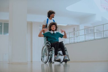 Afrikalı Amerikalı bir öğrenci, arkadaşlarını tekerlekli sandalyeyle modern bir okula sokuyor. Engelli insanlara yardım etme gücünü, ulaşılabilirliğini ve arkadaşlığın gücünü gösteriyor..