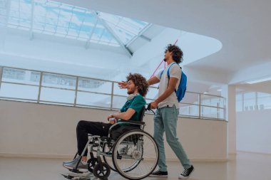 Afrikalı Amerikalı bir öğrenci, arkadaşlarını tekerlekli sandalyeyle modern bir okula sokuyor. Engelli insanlara yardım etme gücünü, ulaşılabilirliğini ve arkadaşlığın gücünü gösteriyor..